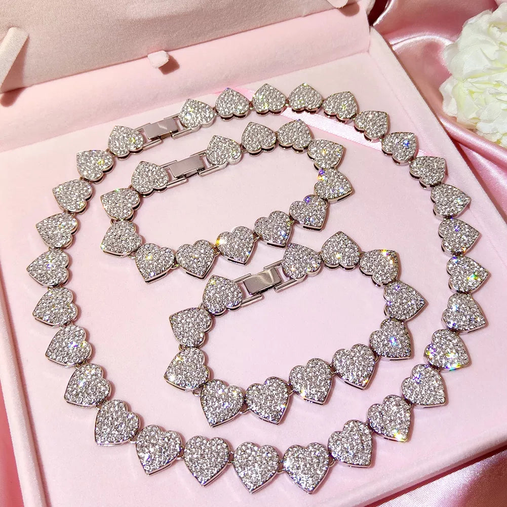 A set of heart-shaped chain necklace and bracelet, fully encrusted with rhinestones, displayed in gold and silver color options.